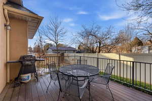 Wooden terrace featuring outdoor dining space, a fenced backyard, and a grill