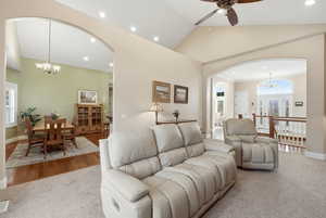 Living area featuring a chandelier, arched walkways, ceiling fan, high vaulted ceiling, and recessed lighting