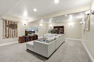 Living area with beam ceiling, recessed lighting, and carpet