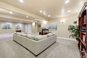 Living area with light colored carpet and recessed lighting