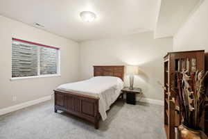 Bedroom with baseboards and light colored carpet