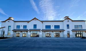 Back of property featuring stone siding, a standing seam roof, and a metal roof