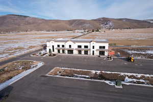 Snowy aerial view with a mountain view and a rural view