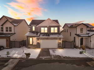 View of front of property with a gate, a garage, concrete driveway, and board and batten siding