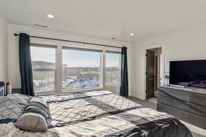 Primary Bedroom with large windows and view of mountains and attached bathroom with walk in closet