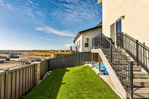 Rear view of the property with a deck, fully landscaped yard, and a patio
