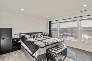 Primary Bedroom with large windows and view of mountains