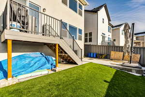 Rear view of the property with deck, fully landscaped yard, and a patio