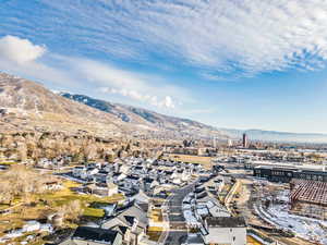 Aerial perspective of suburban area with mountains. Lagoon in background.