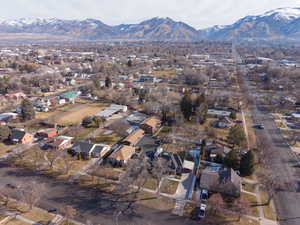Aerial view of property and surrounding area featuring nearby suburban area and a mountainous background