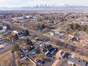 Aerial view of property and surrounding area with nearby suburban area and mountains
