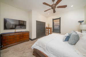 Bedroom with light carpet, a ceiling fan, a closet, and recessed lighting