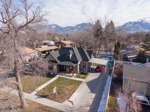 View of front of property with a porch, driveway, a mountain view, and a residential view