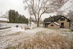 Yard layered in snow featuring a patio, a fenced backyard, and an outdoor fire pit