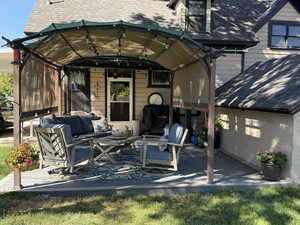 Back of house featuring an outdoor hangout area and a shingled roof
