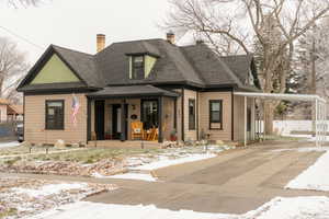 View of front facade with covered porch, a carport, concrete driveway, and a shingled roof