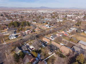 Aerial view of property and surrounding area featuring mountains and nearby suburban area