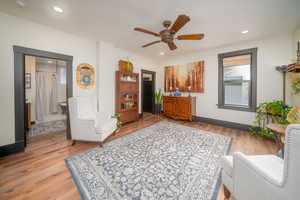 Sitting room with light wood finished floors, a ceiling fan, and recessed lighting