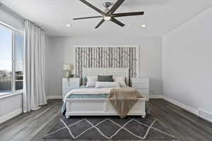 Bedroom with ceiling fan and dark wood-type flooring