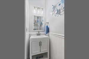 Bathroom with a wainscoted wall and vanity