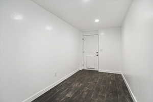 Unfurnished room with dark wood finished floors and recessed lighting