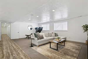Living area featuring baseboards and dark wood-style floors