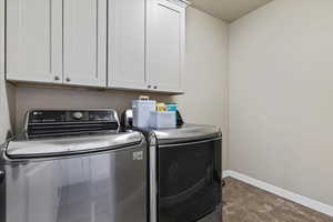 Laundry room featuring washing machine and clothes dryer and cabinet space