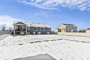 Snow covered property with a fenced backyard, a patio area, and stairway