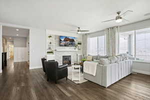 Living room featuring a tile fireplace, a ceiling fan, dark wood finished floors, recessed lighting, and built in features