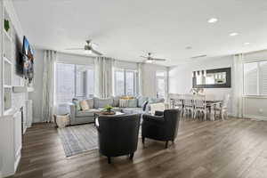 Living area with a fireplace, wood finished floors, and ceiling fan