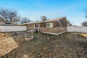 Back of house featuring brick siding and a fenced backyard 890