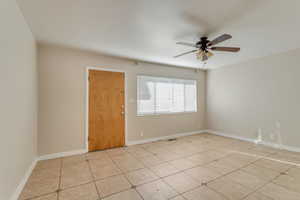 Unfurnished room with ceiling fan and light tile patterned flooring 890
