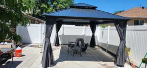 Fenced backyard with a gazebo, a patio area, and a gate