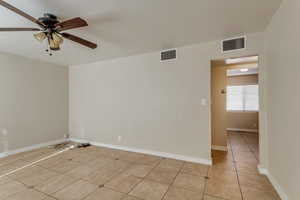 Unfurnished room featuring ceiling fan and light tile patterned floors 890