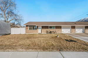 Ranch-style house with brick siding, an attached garage, driveway, and roof with shingles