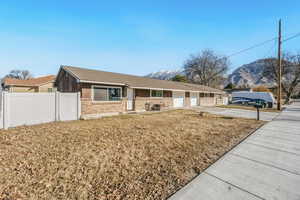 Ranch-style home featuring concrete driveway, brick siding, a mountain view, and an attached garage
