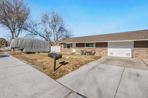View of front of property with brick siding, a shingled roof, and driveway