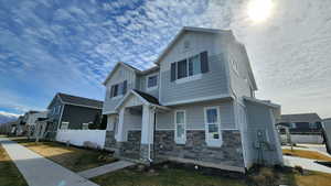 Craftsman-style house featuring board and batten siding, a residential view, and stone siding