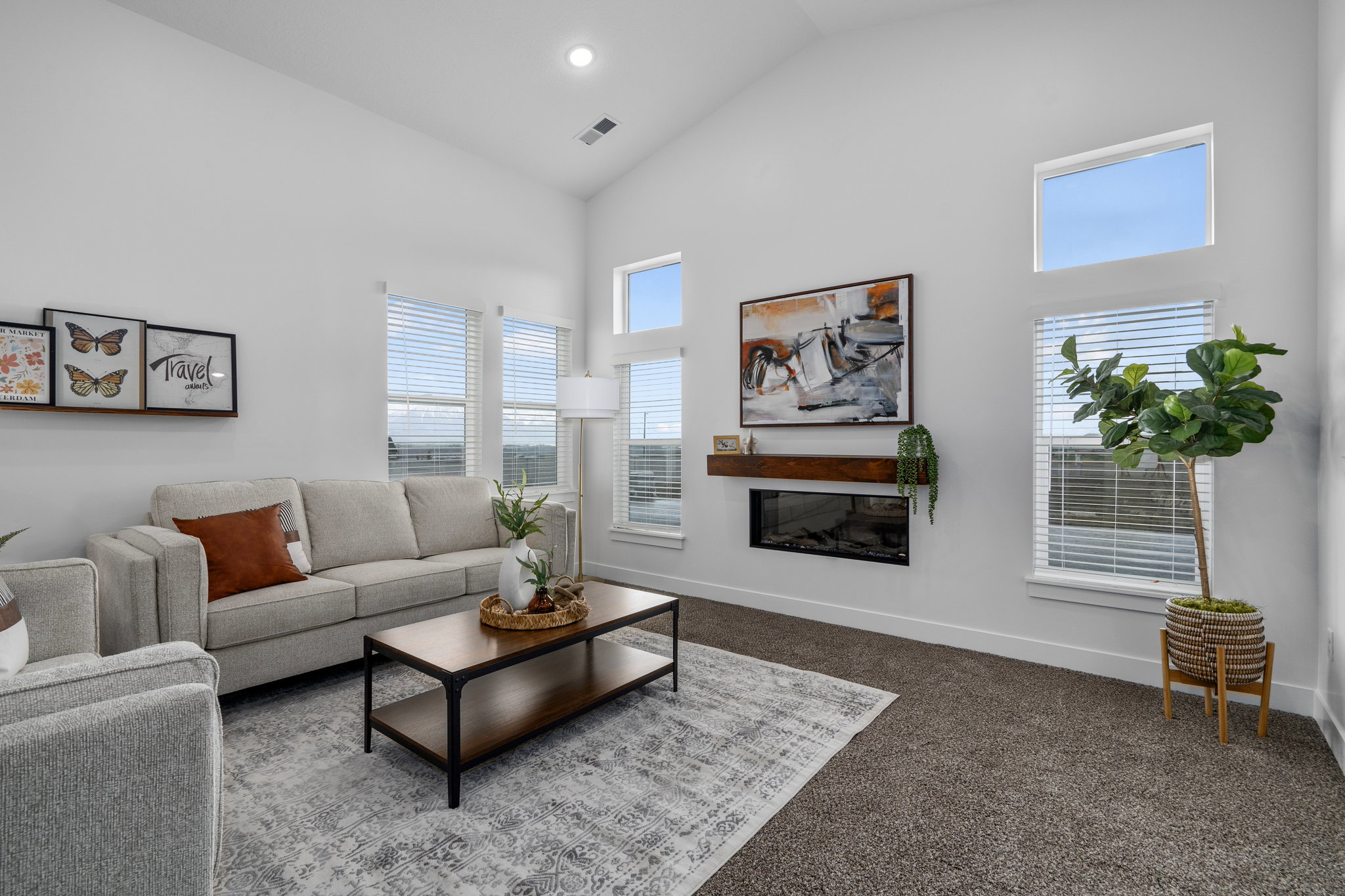 Great room with vaulted ceilings and cozy fireplace. Opens to kitchen and dining room.