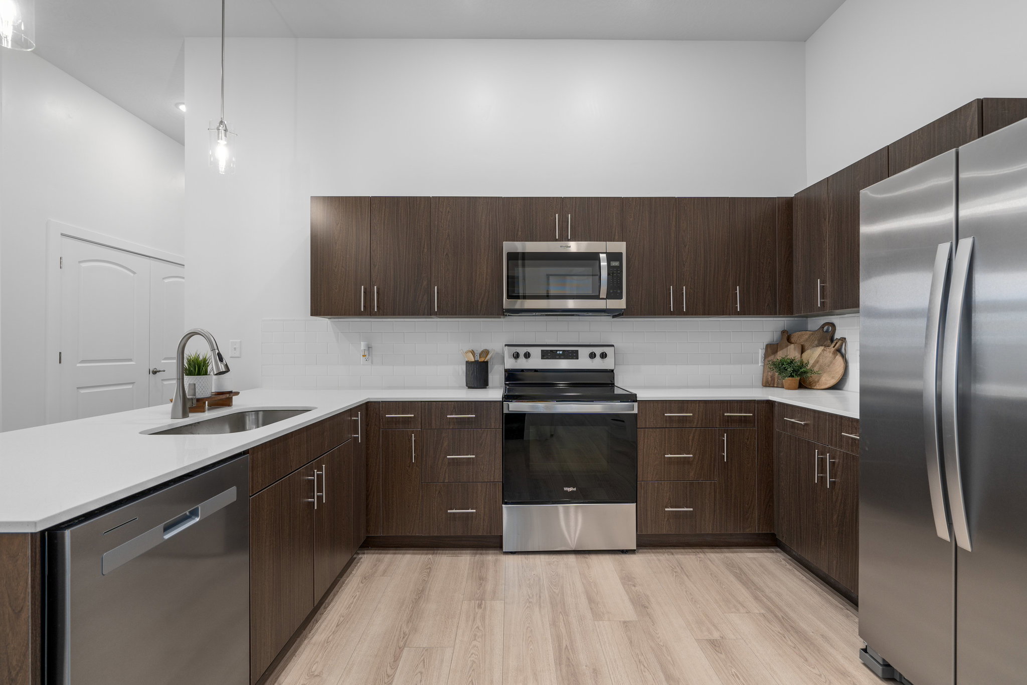 Quartz counters with tile backsplash and stainless steel appliances. *Fridge not included.