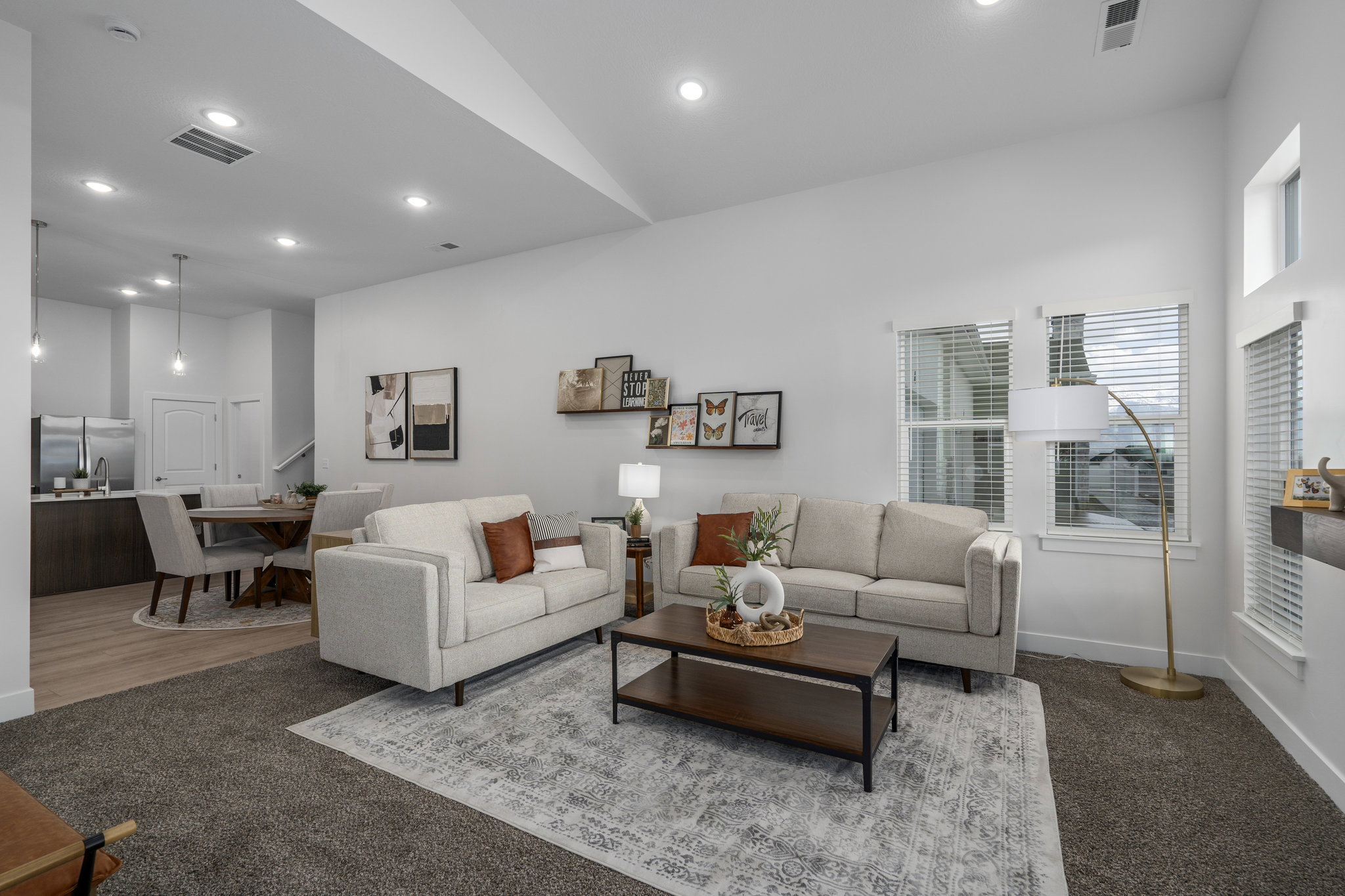 Great room with vaulted ceilings and cozy fireplace. Opens to kitchen and dining room.