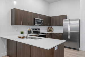 Quartz counters with tile backsplash and stainless steel appliances. *Fridge not included.