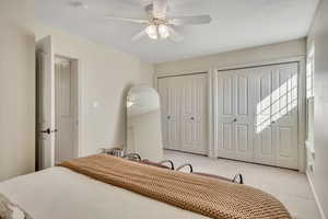 Bedroom featuring carpet flooring, two closets, and a ceiling fan