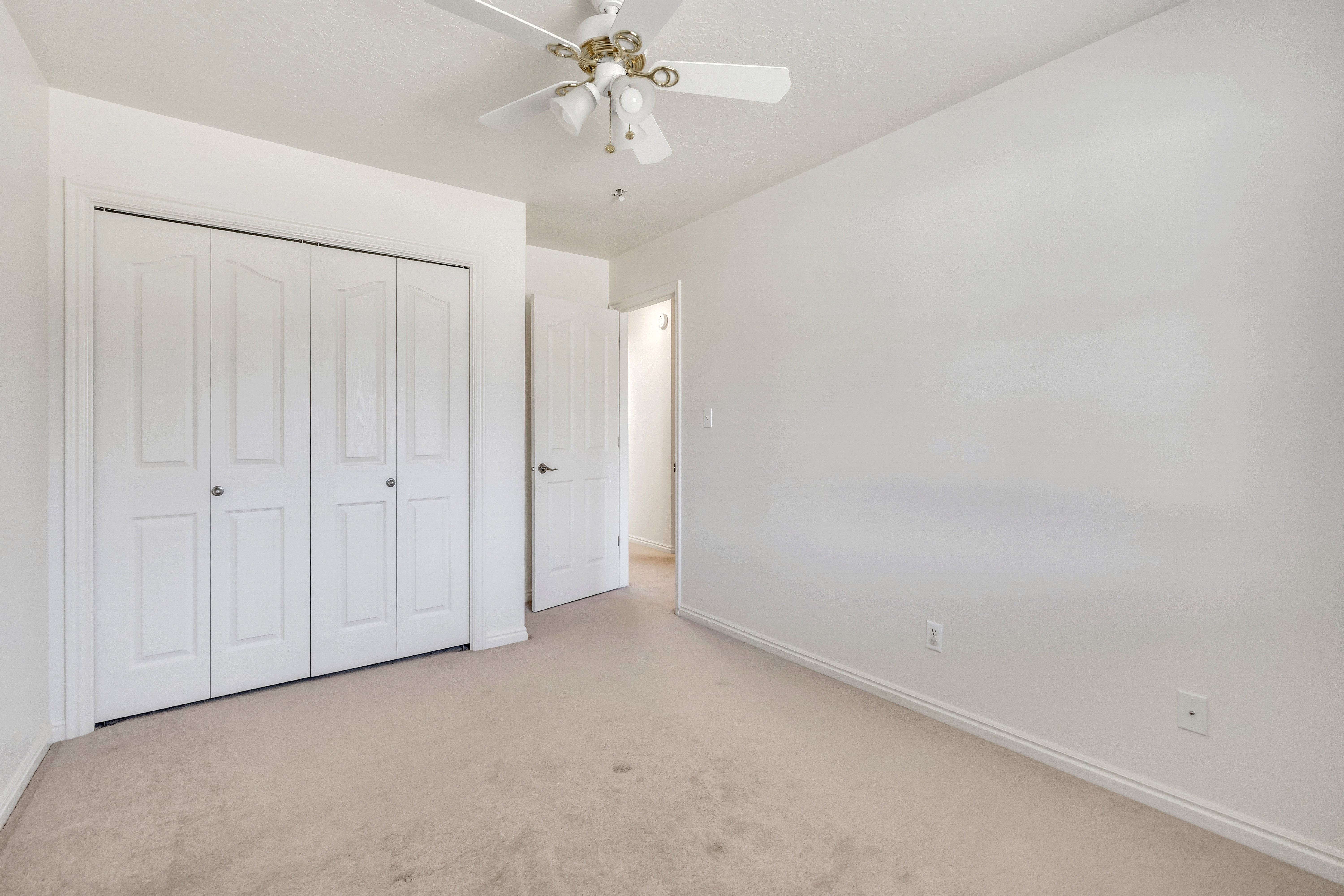 Unfurnished bedroom featuring carpet, a ceiling fan, and a closet