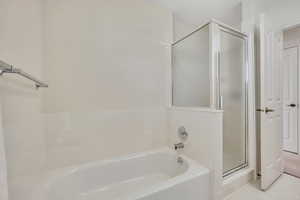 Bathroom featuring a shower stall and a garden tub