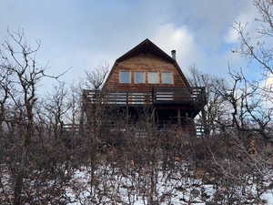 Back of property with a gambrel roof and a wooden deck