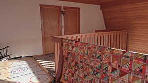 Rec room with lofted ceiling and light carpet