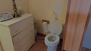 Half bath featuring toilet and light wood finished floors