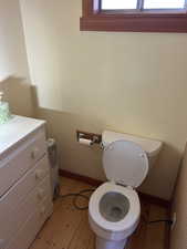 Half bathroom with light wood-type flooring and vanity