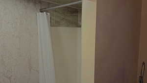 Bathroom view of a shower with curtain